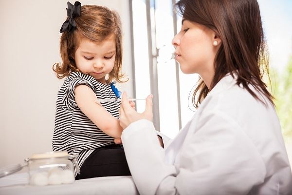Doctor giving little girl a vaccine