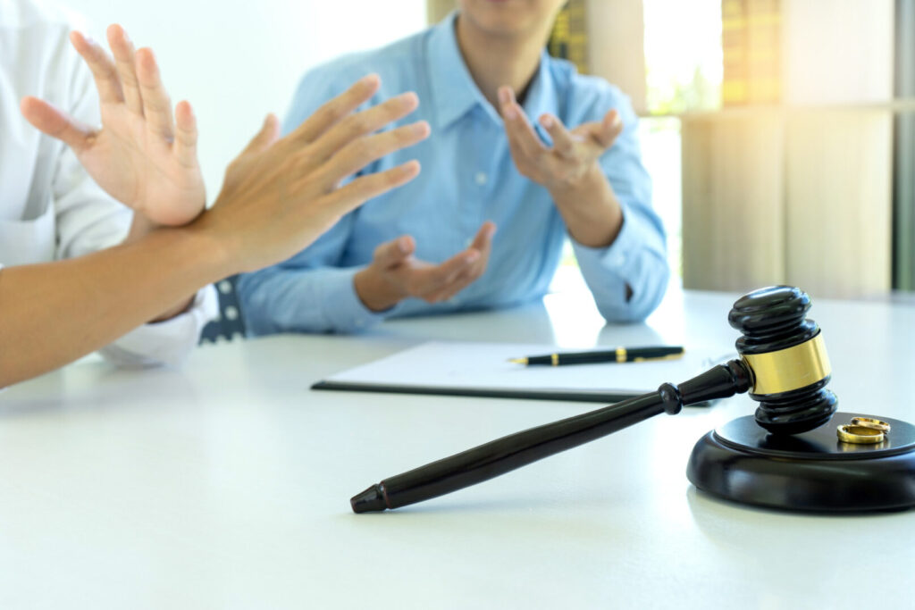 woman and man quarrel in front of gavel on the table with paper for sign
