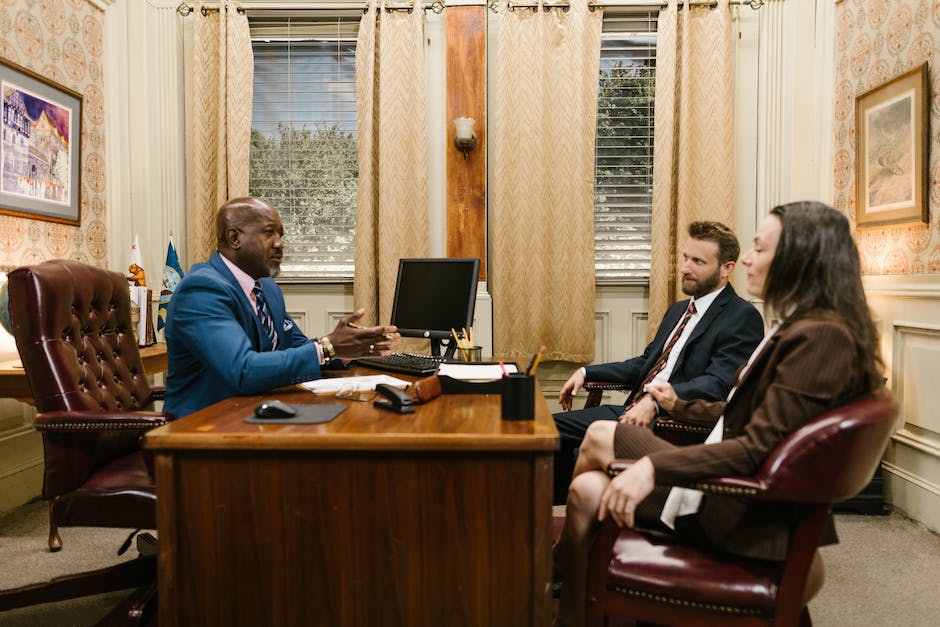 Couple sitting with lawyer at desk in office