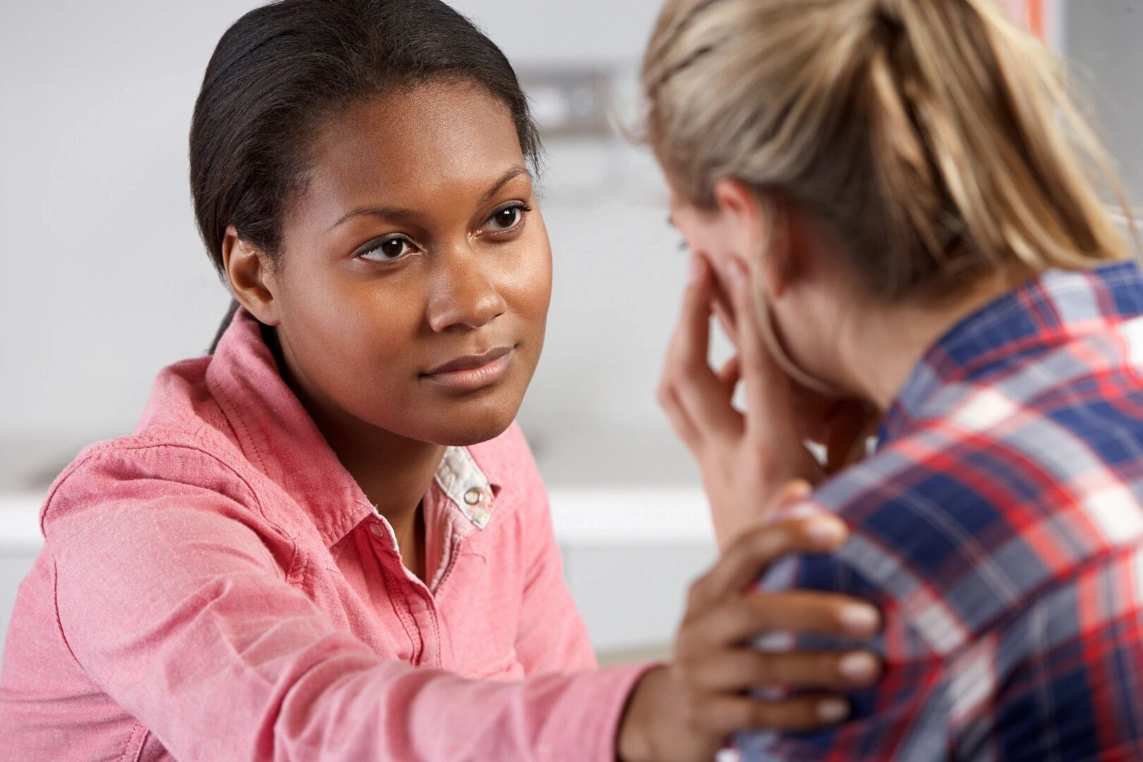woman comforting another and Addressing Domestic Abuse in Divorce Cases