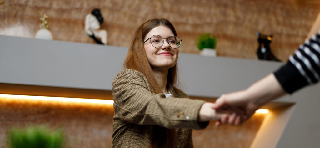 Young white woman shaking hands