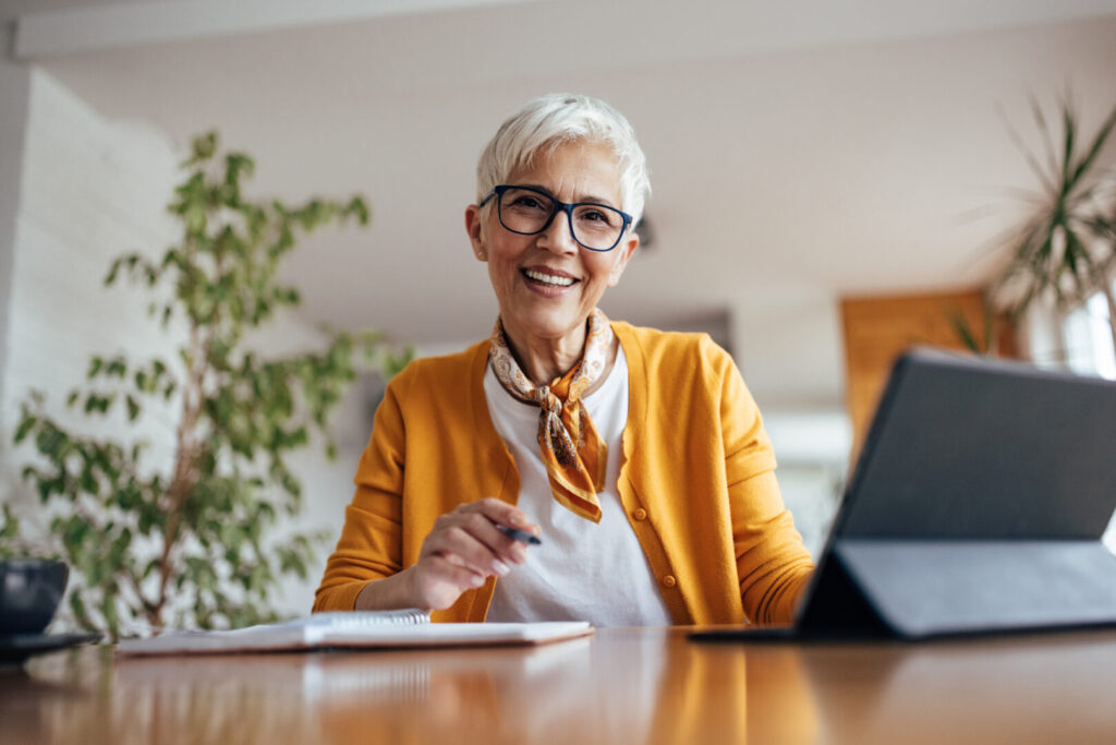 Senior woman, happily posing at home office.