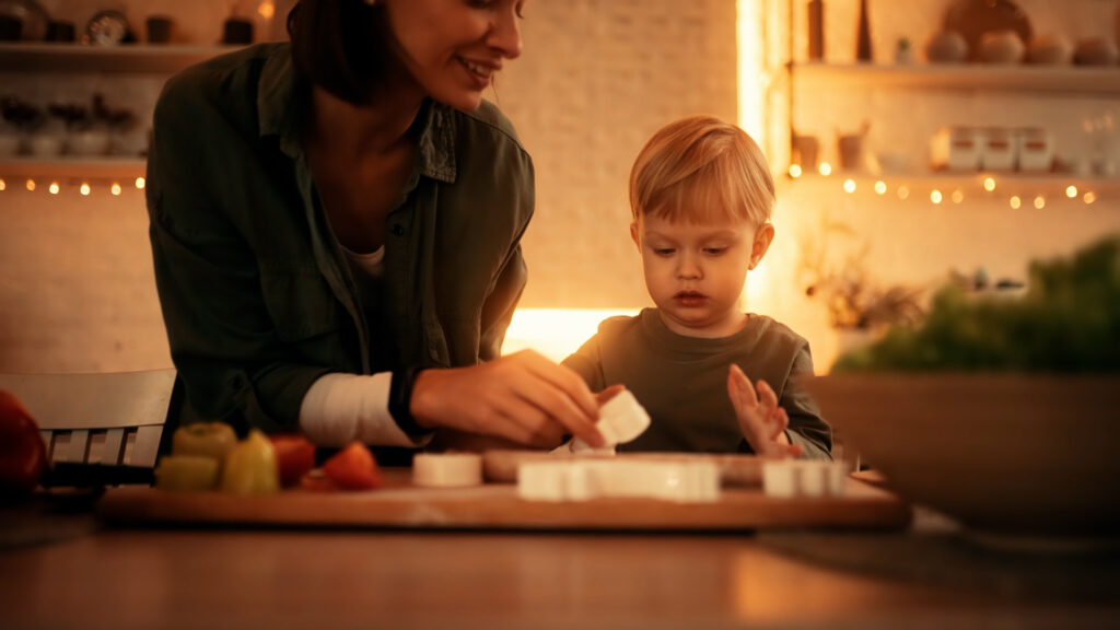 Young son and mother making holiay cookies