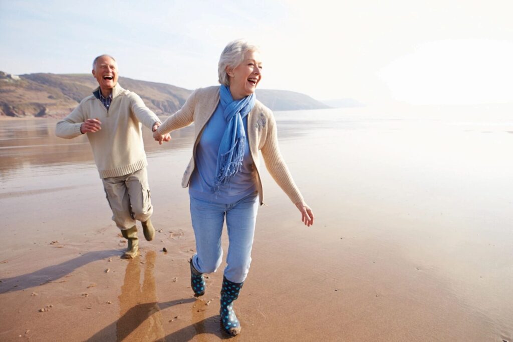 older couple runningon an ocean beach