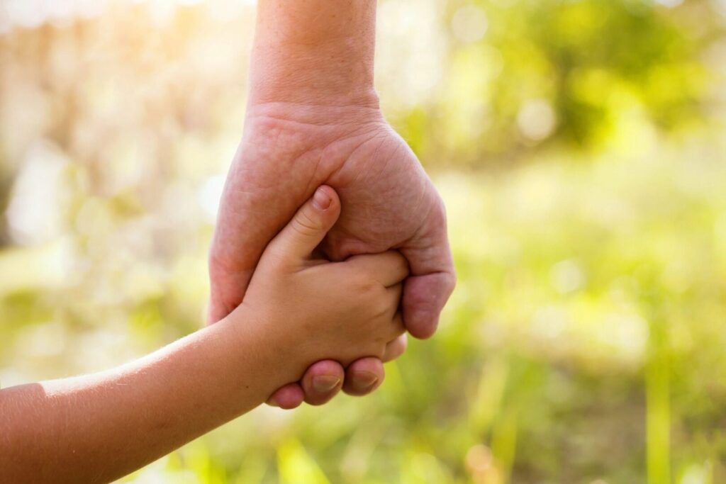 close up of father and son holding hands